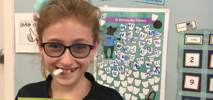 Photo of student with certificate for losing a tooth